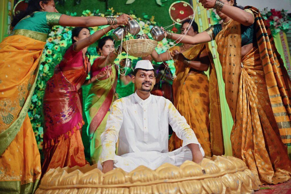 Groom surrounded by family women performing rituals during Haldi Ceremony