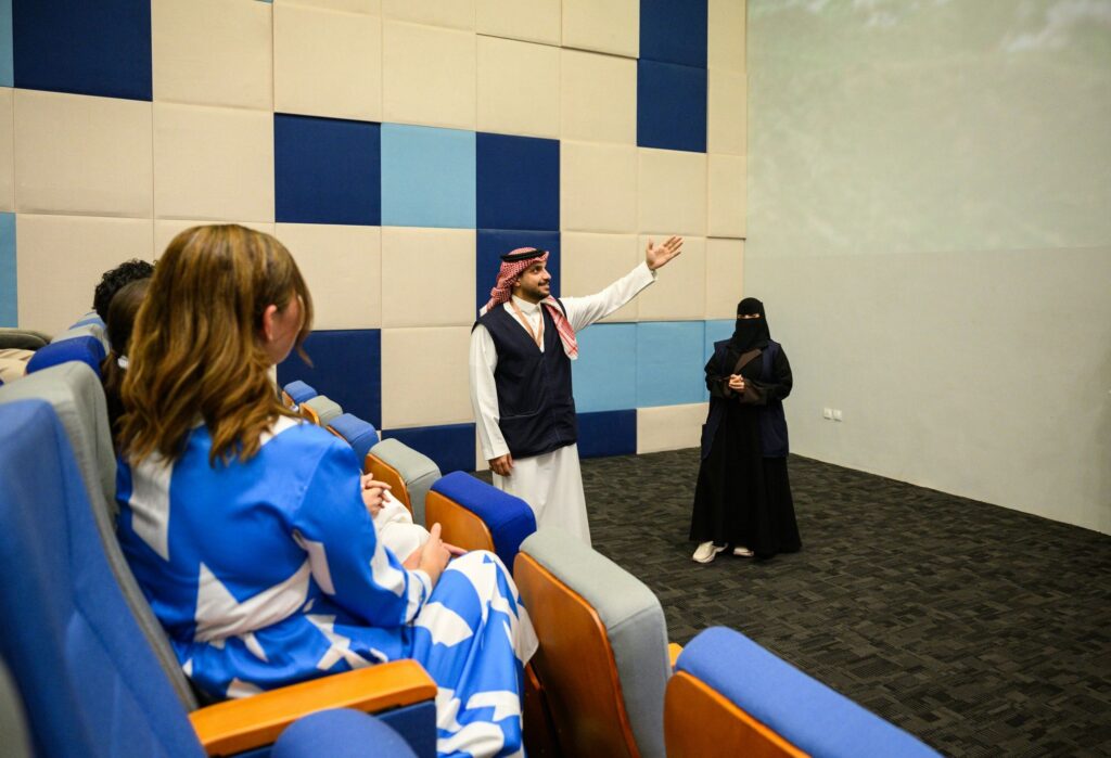 Arab Guide Addressing Diverse Tourists in Auditorium